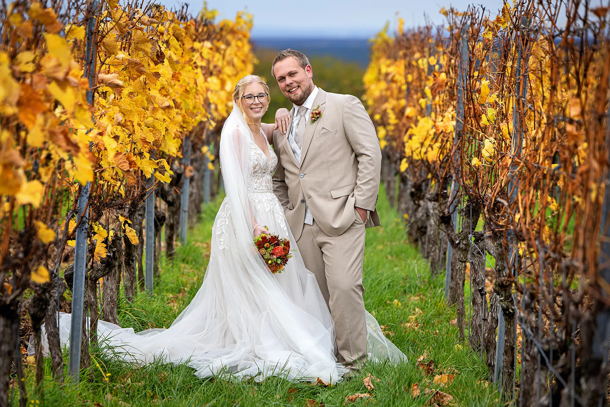 Brautpaar im Weinberg vor gelbem Herbstlaub