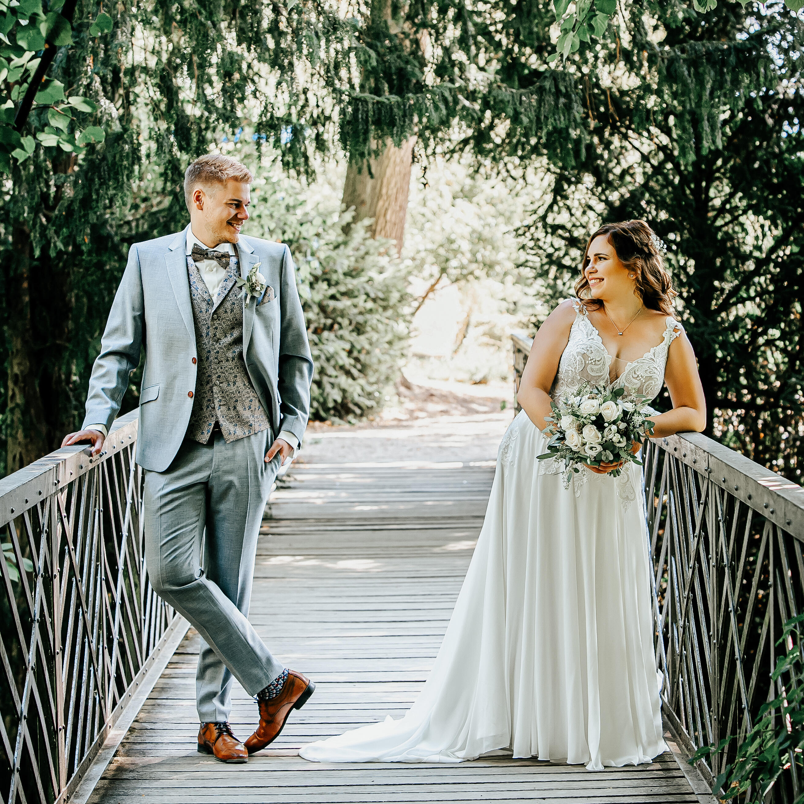 Brautpaar auf einer Brücke schaut sich gegenseitig an